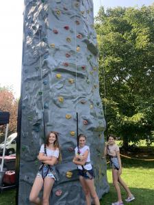 smiling girls next to the climbing wall