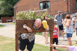 Man in stocks being splashed with a wet sponge