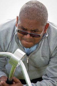 A man concentrating while playing on a giant buzz wire game trying to keep a steady hand and not set off the alarm.
