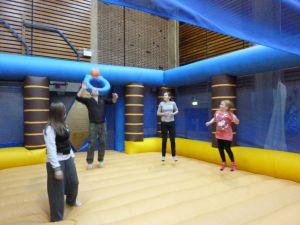 Image of four people playing bouncy volleyball inside the inflatable sports arena.