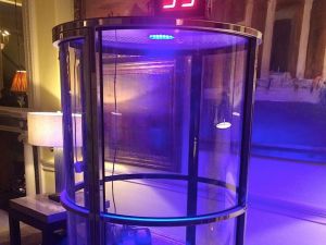 Close up of a cash grabber machine with colour chaining LED light, illuminating the game at an evening event.