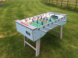 Blue Foosball Table at an event in a field with red and blue players on the table game.