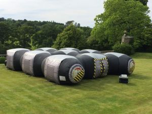 Inflatable laser tag game set up in a garden for a laser tag party. The game is played inside the inflatable arena which is darkened and has lots of hiding places.