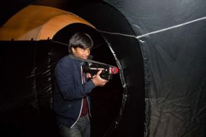 Man playing laser tag inside an inflatable laser tag arena and trying to shoot his opponents.