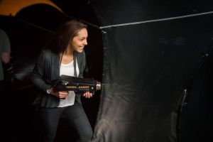 Girl playing laser tag inside an inflatable dome and trying to shoot her opponents laser tag gun.
