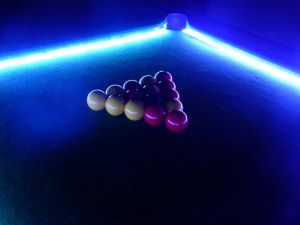 Pool table complete with LED lighting which is shining on the pool balls.