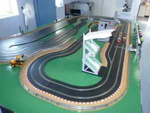 Scalextric racing game complete with slot car track, cars and grand stand buildings.