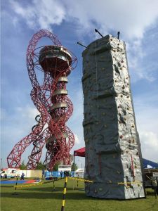 Mobile rock climbing wall at the Olympic Park in Stratford London. The climbing wall is at a corporate fun day next to The Orbital structure within the park.