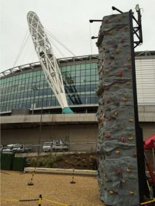 Mobile rock climbing wall at an event at Wembley Stadium in London. The Climbing Wall is next to the Football stadium for a corporate event.
