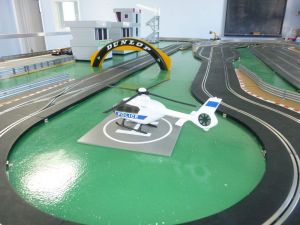 Police helicopter landing on a Scalextric racing track.