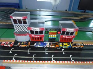 Scalextric cars lined up on the grid of a slot car track.