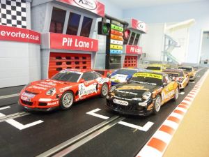 Close up of slot cars racing around a Scalextric circuit at an event.