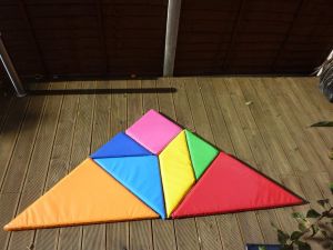 Tangram puzzle assembled into a triangular shape at a team building event.