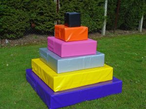 Giant towers of hanoi team building puzzle with six brightly coloured pieces.