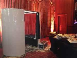 A white photo booth set up at an event ready for guests to have their photo taken.