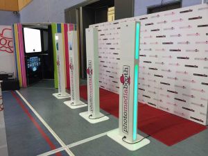 Four Photo Media Booths set up with a red carpet and backdrop ready for guests to have their photos taken.