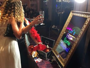 Two girls standing in front of a Magic Selfie Mirror, ready to have their photos taken.