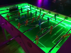 LED table football with customised green LED lights illuminating the table game.