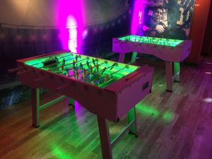 A pair of LED foosball tables with green playing surface selected.