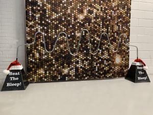Our Christmas Buzz Wire wearing Santa hats infant of a glittery background