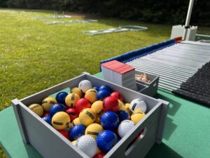 golf clubs, balls, score sheets and pencils